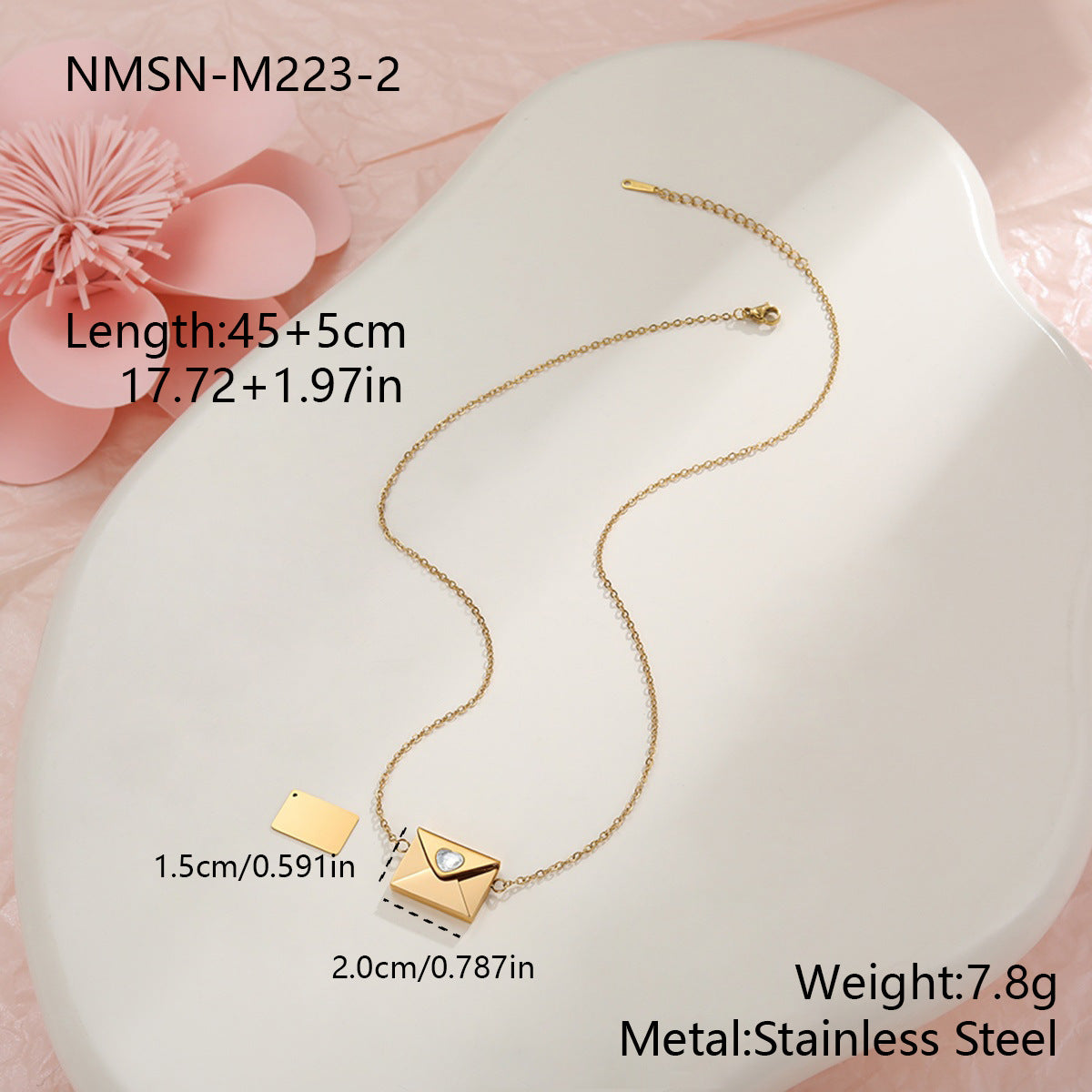 Gold necklace with pendant on a white heart-shaped pillow with pink flowers in the background