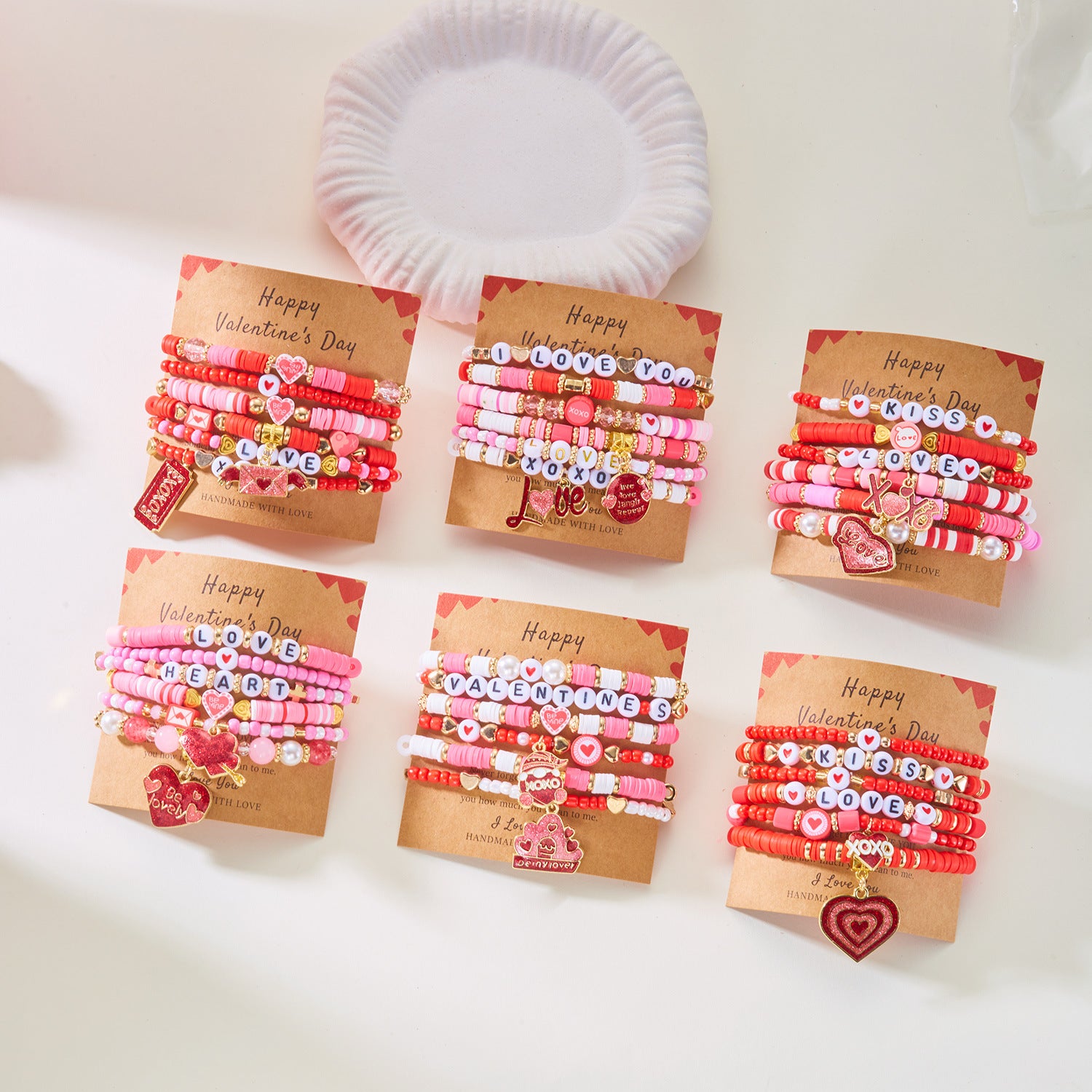 Set of Valentine's Day-themed bracelets stacks on a white surface