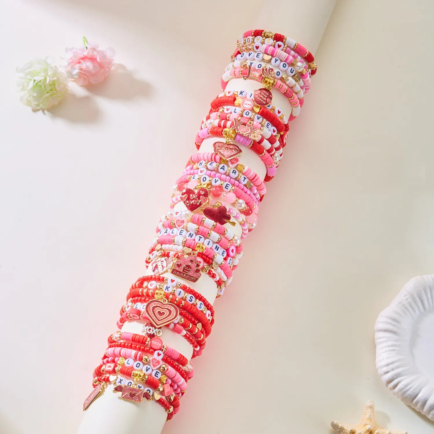 Stack of colorful bracelets on a white surface with decorative elements.