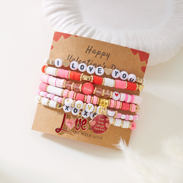 Set of colorful bracelets with heart and letter charms on a 'Happy Valentine's Day' card.