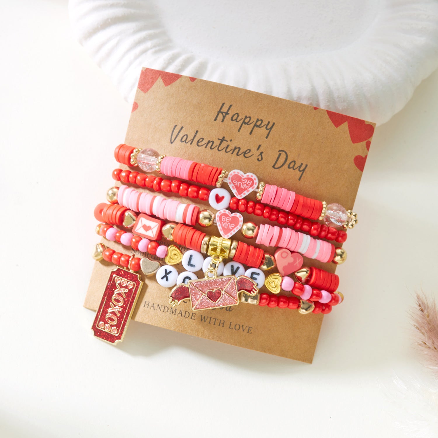Set of colorful beaded bracelets on a 'Happy Valentine's Day' card with a white background