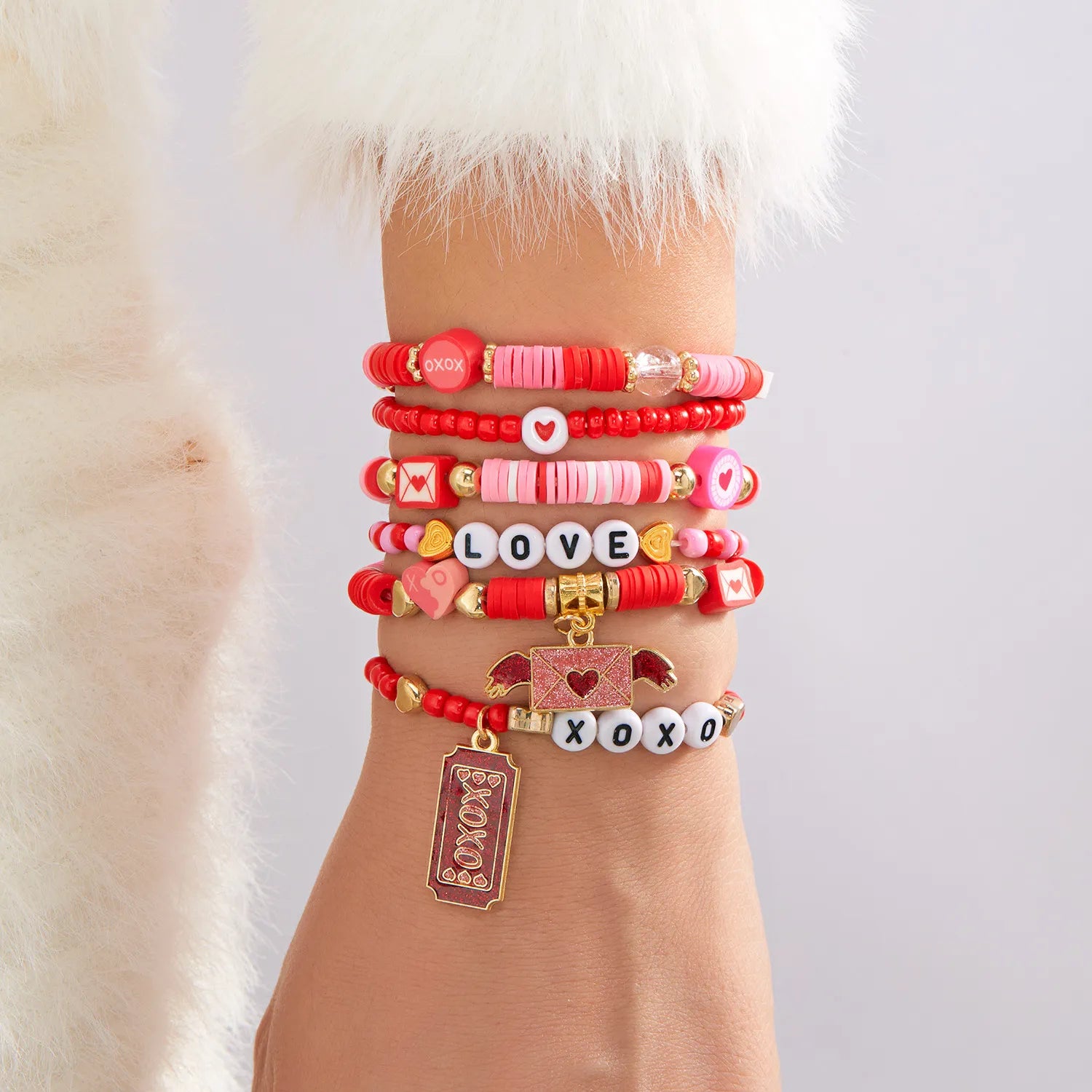 Multiple colorful bracelets on a wrist with a fur background