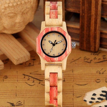 Wooden watch with red accents on a surface with music sheet background
