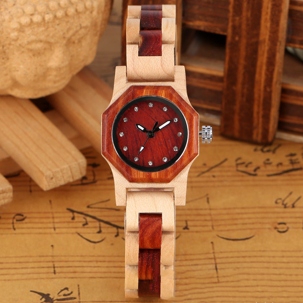 Wooden wristwatch with red face on a sheet of music