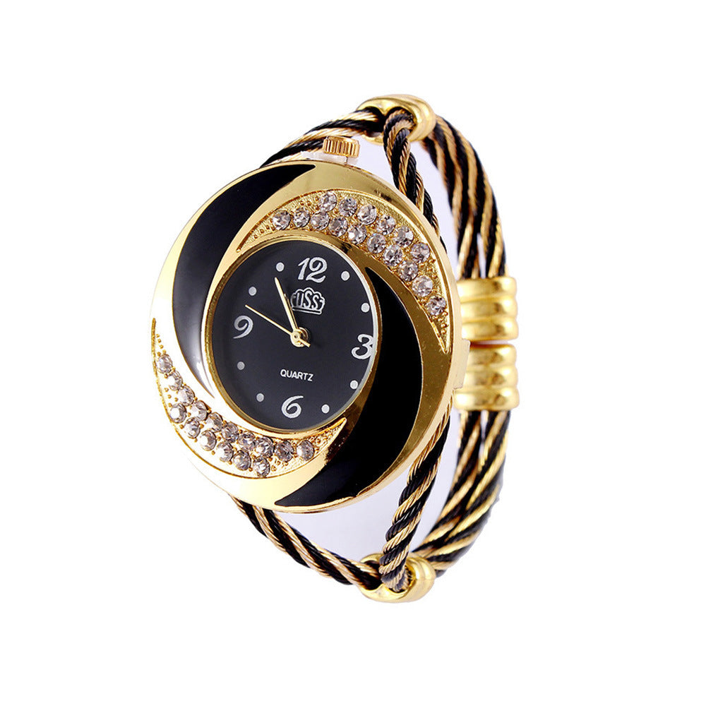 Gold and black watch with decorative band on a white background