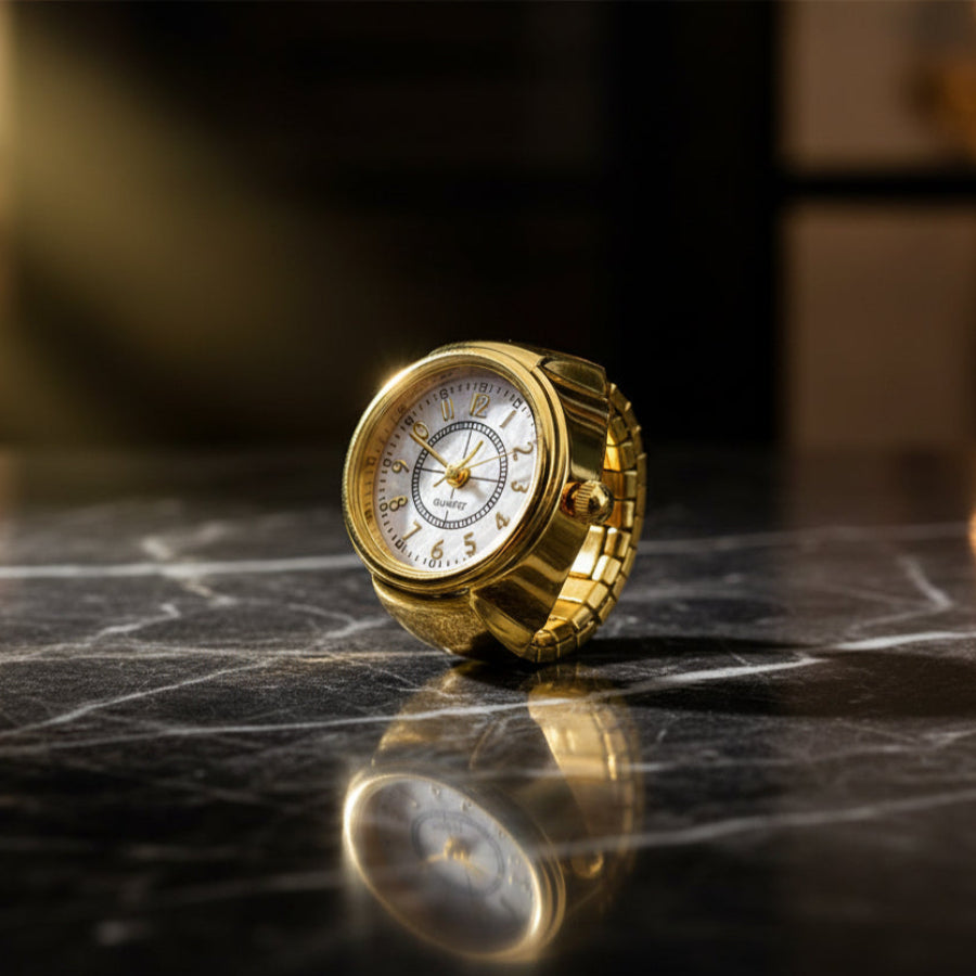 Gold clock on a reflective marble surface with a blurred background