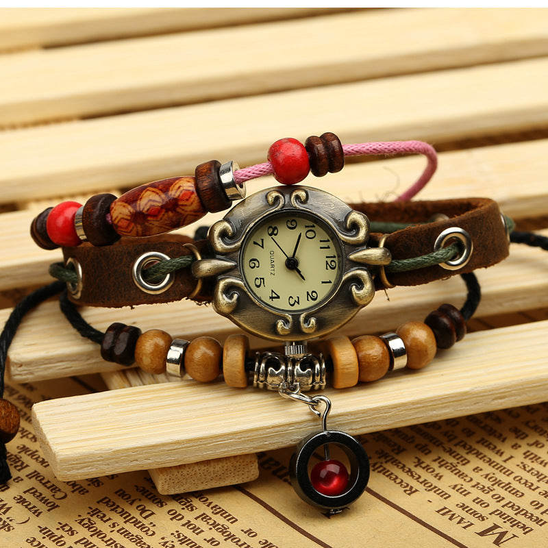 Decorative wristwatch with beads on a wooden surface