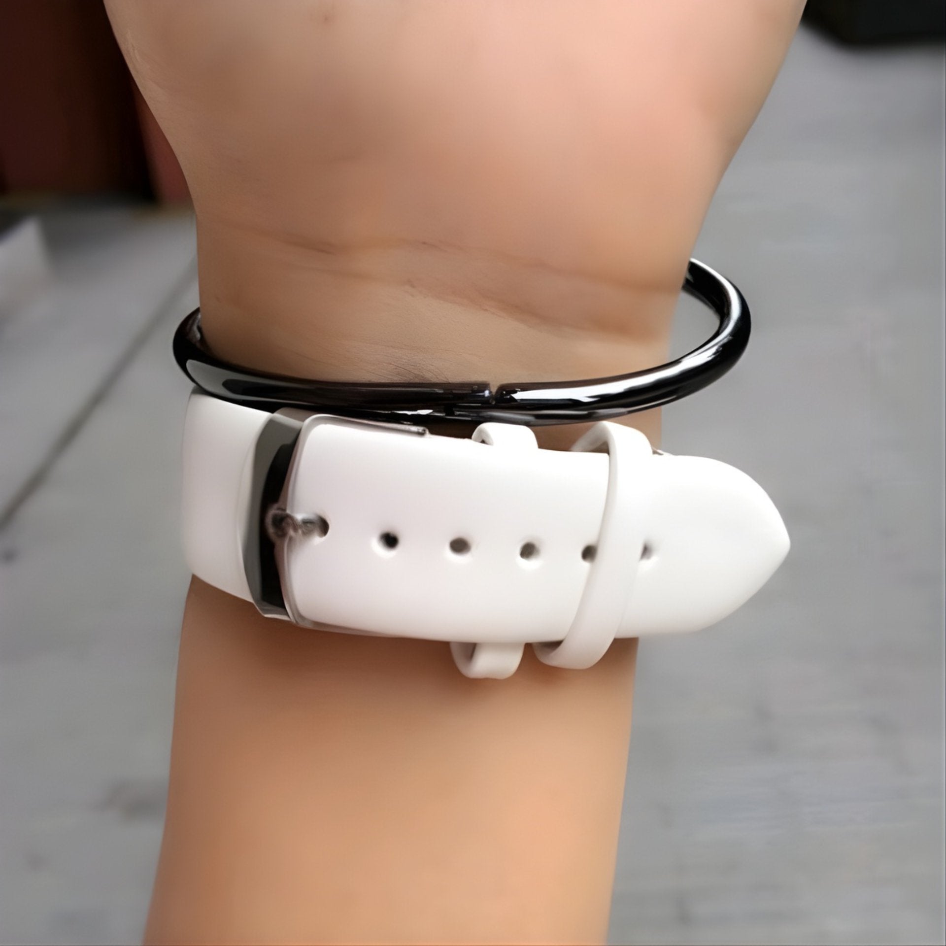 White watch with black strap on wrist against a neutral background