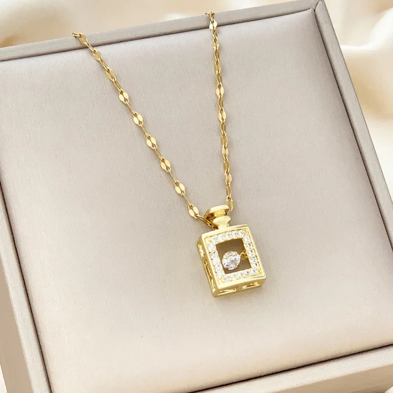 Gold necklace with a square pendant on a beige surface