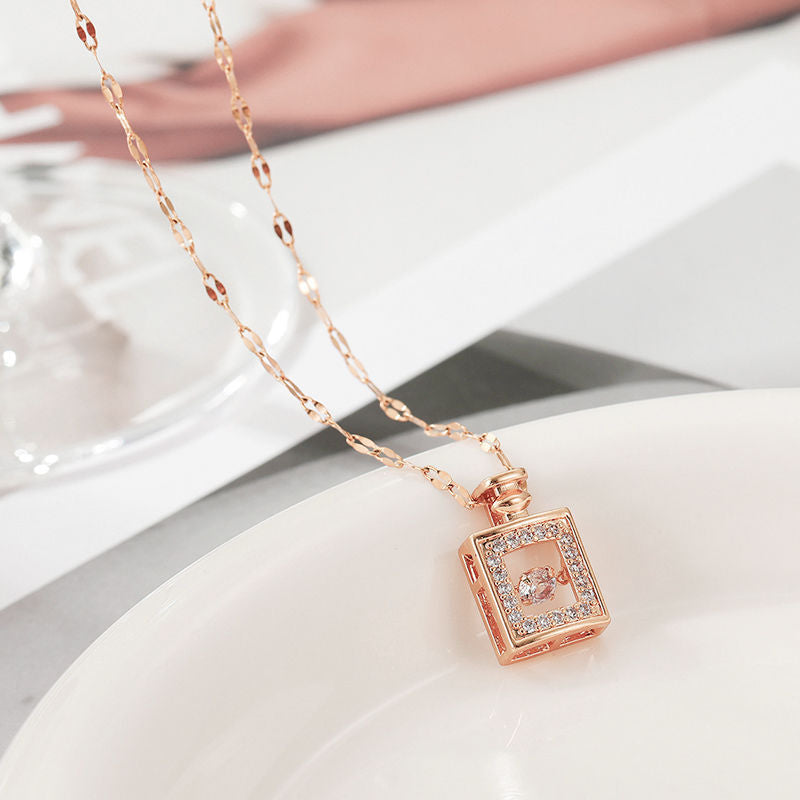 Rose gold necklace with a square pendant on a white surface