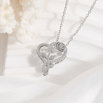 Silver heart-shaped necklace with rose design on a white background