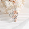 Rose gold and silver heart-shaped pendant on a chain against a textured white background