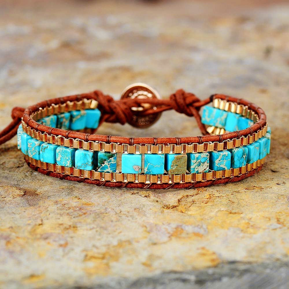 Turquoise and gold beaded bracelet on a stone surface