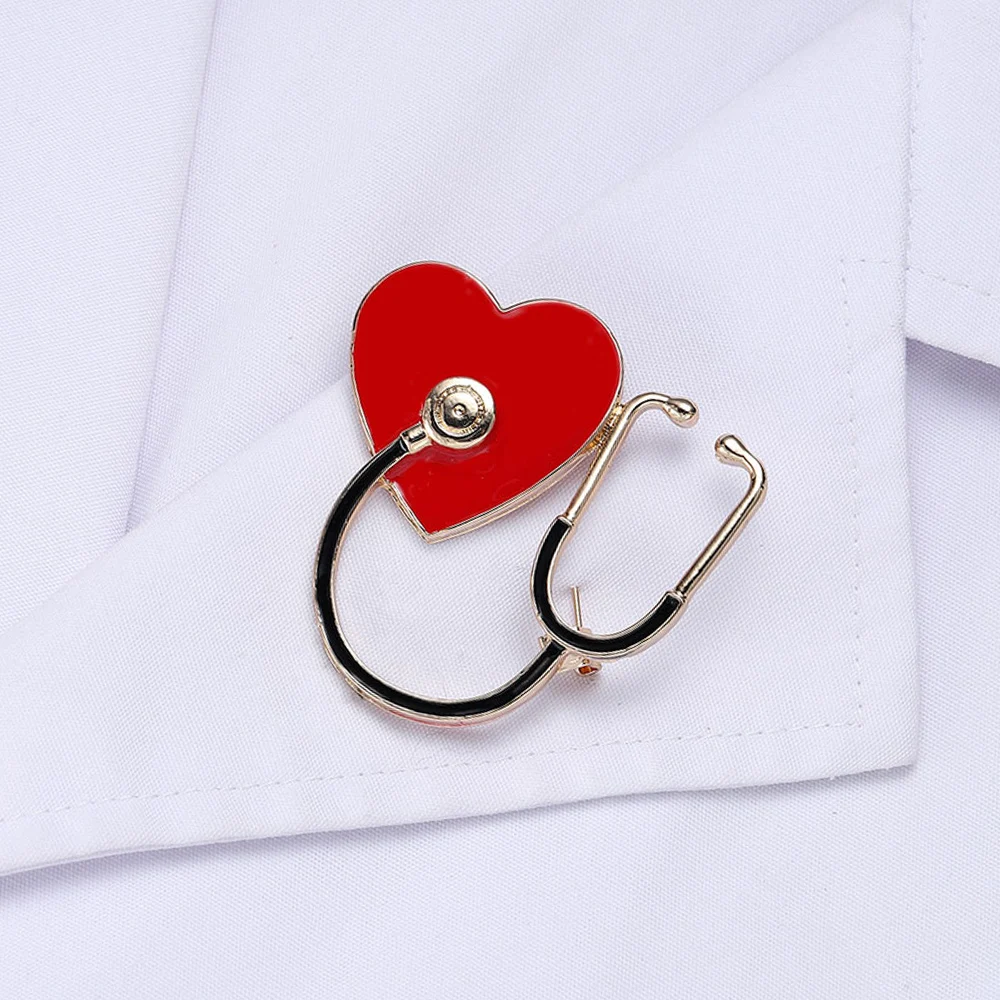 Heart-shaped brooch with stethoscope design on a white background