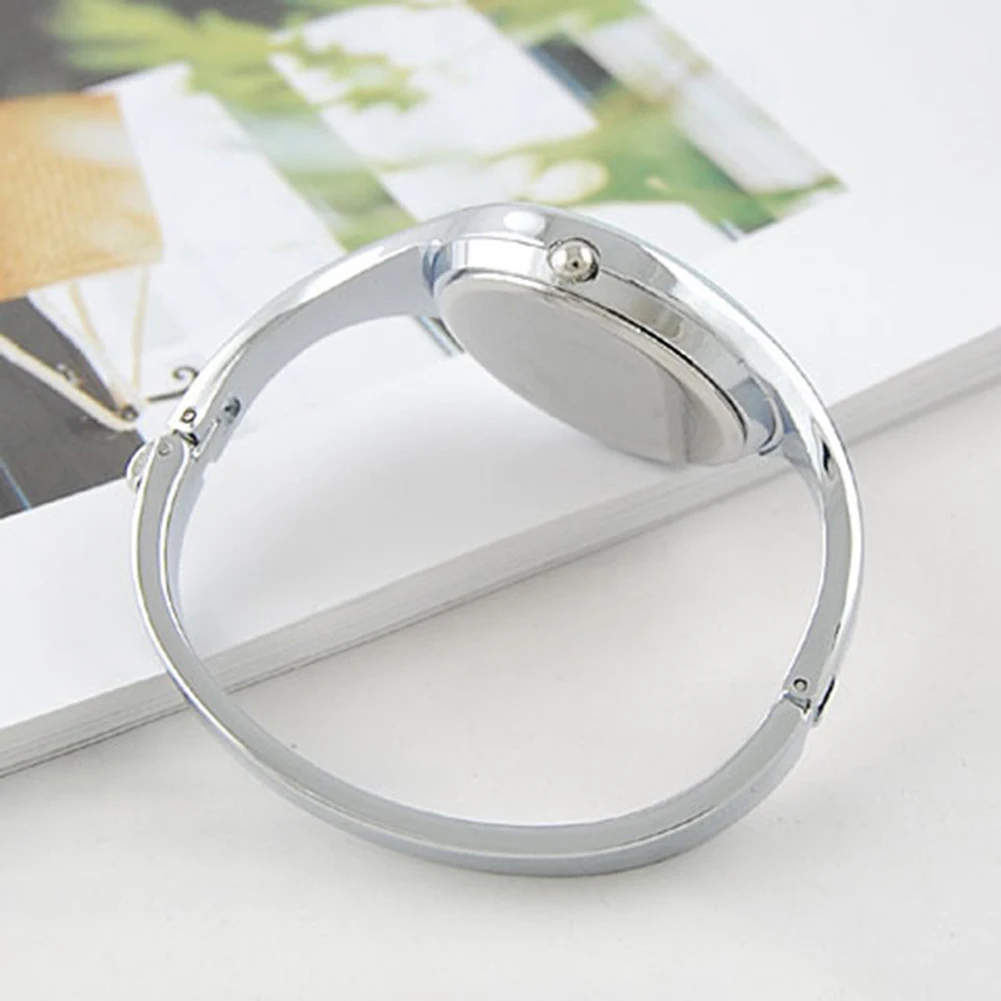 Silver bracelet on a magazine with a blurred outdoor background