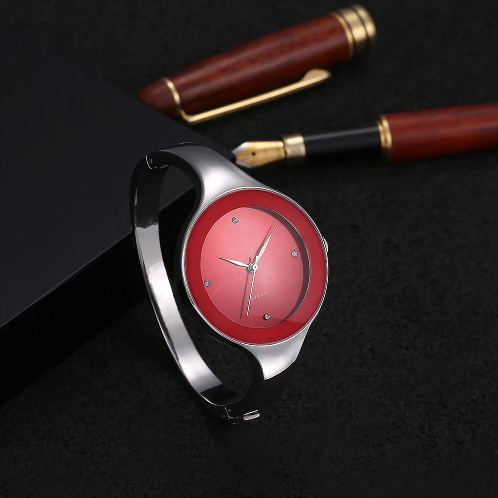 Wristwatch with red face and silver case on a dark background