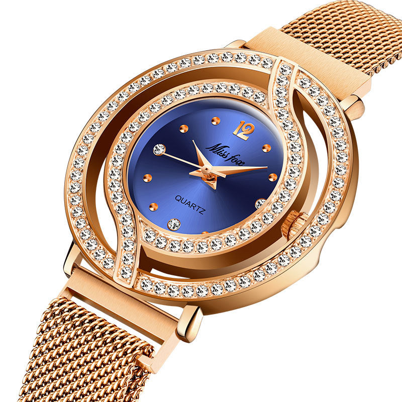 Gold watch with a blue face and diamond-like accents on a white background