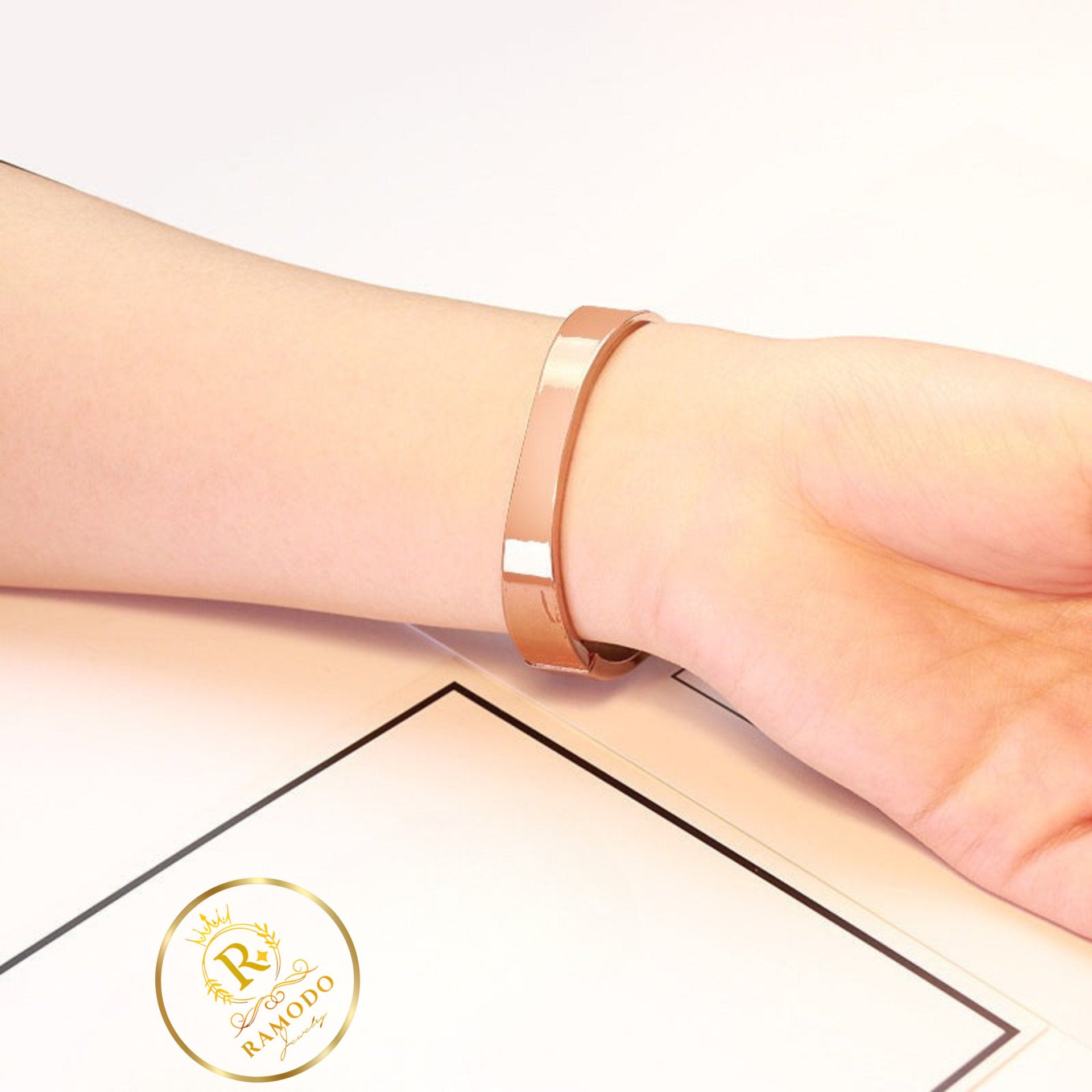 Rose gold bracelet on a wrist with a white background