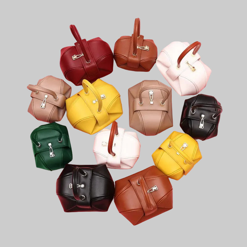 Assorted Luxe leather tote handbags in various colors arranged on a pink background