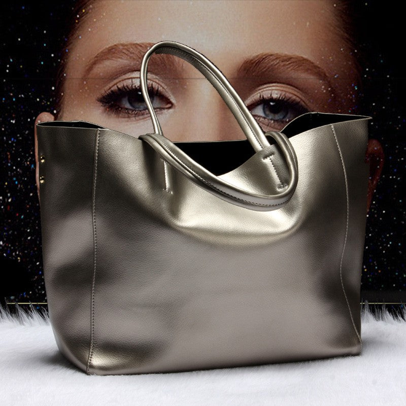Silver handbag in front of a blurred background with a woman's face