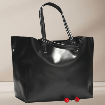 A black cowhide leather tote bag with double handles and top zip closure.