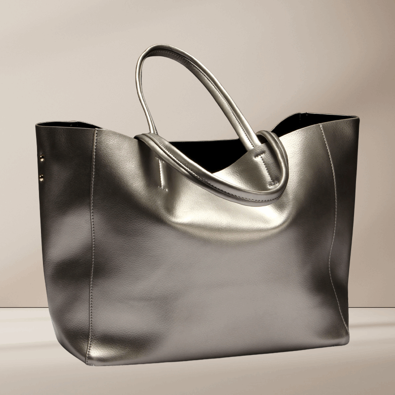 A silver cowhide leather tote bag with double handles and top zip closure.