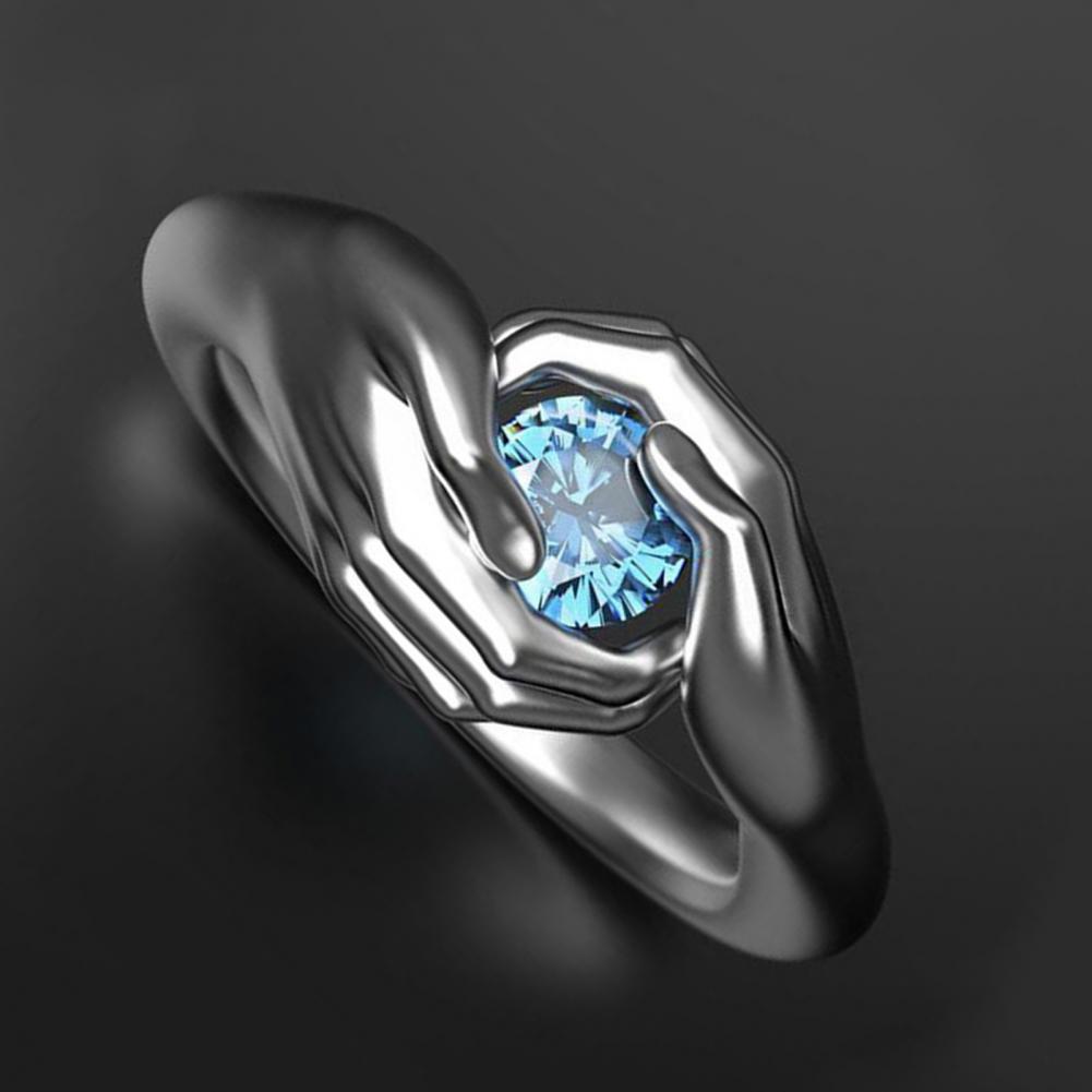 Silver ring with a blue gemstone on a dark background
