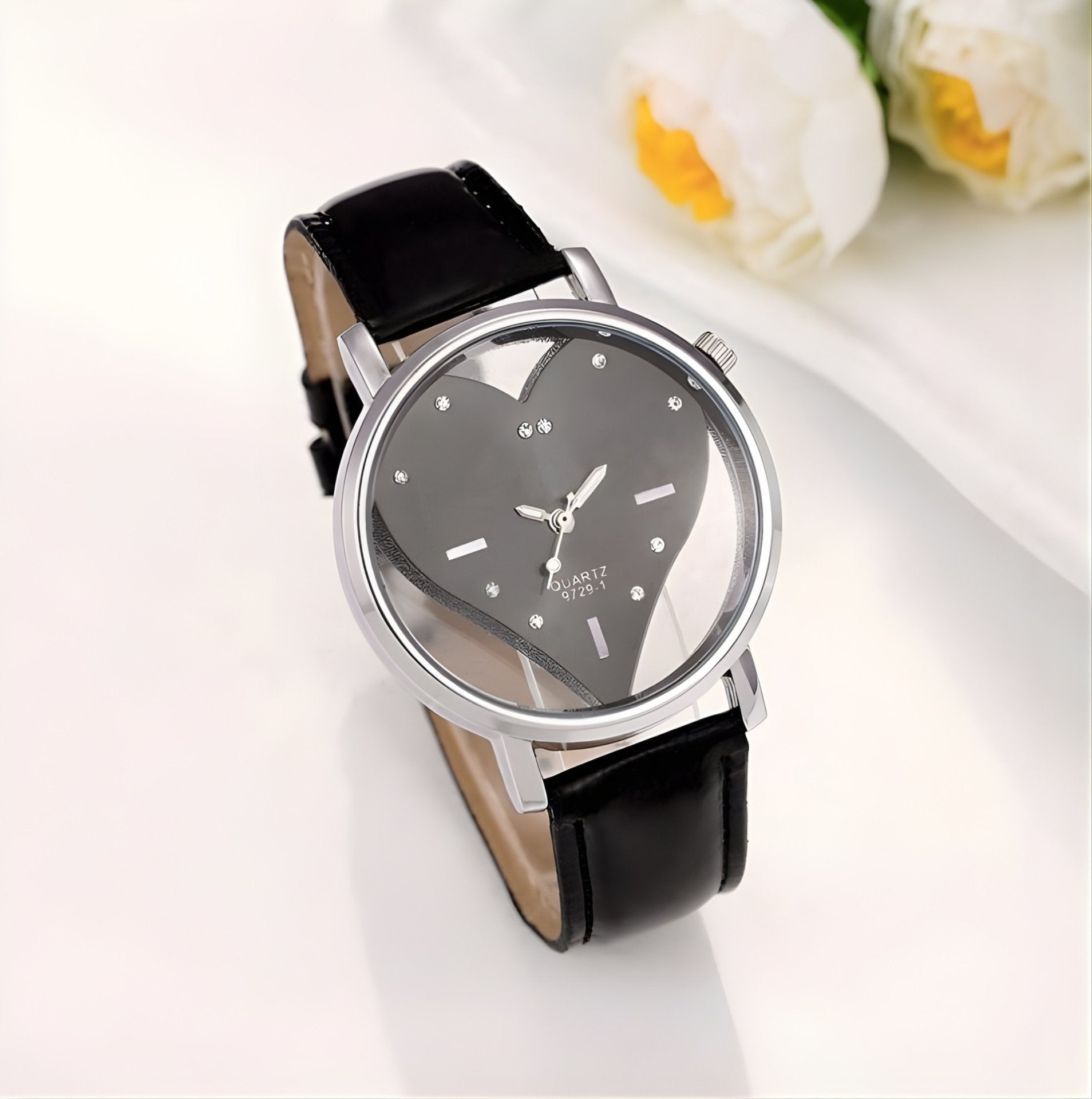 Wristwatch with black leather strap and heart-shaped face on a white background