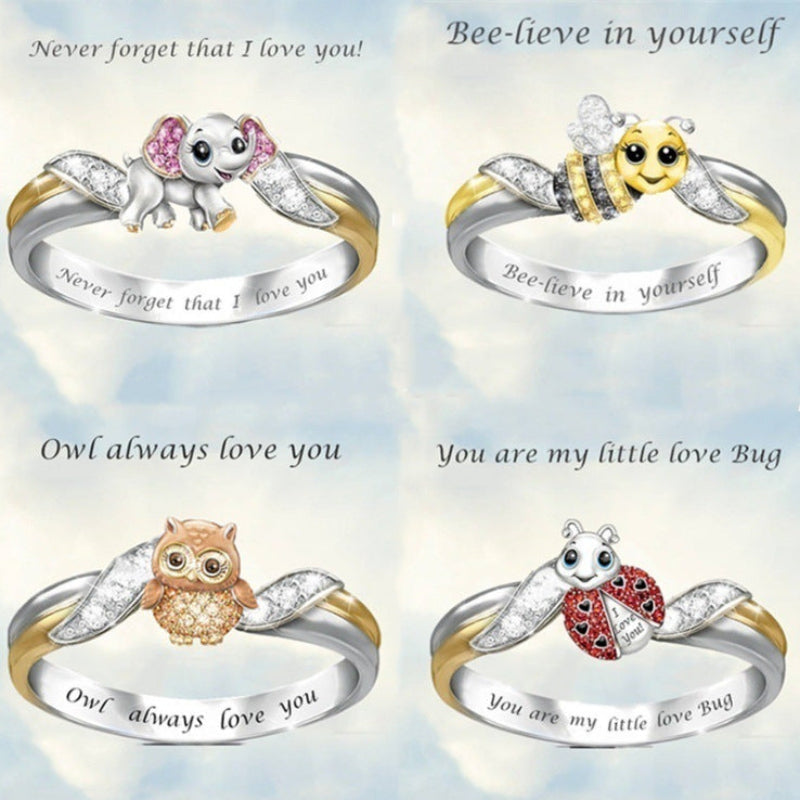 Four decorative rings with animal designs and engraved text on a light blue background.
