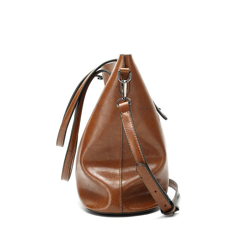 Brown leather handbag with a strap on a white background