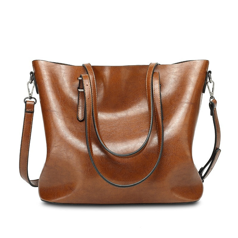Brown leather handbag with a shoulder strap on a white background