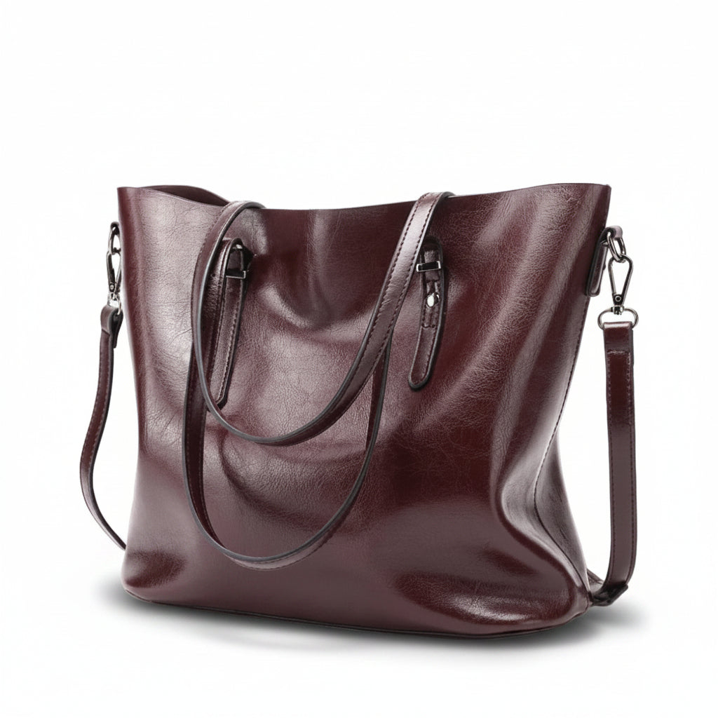 Burgundy leather handbag with a shoulder strap on a white background