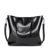 Black leather handbag with shoulder straps on a white background