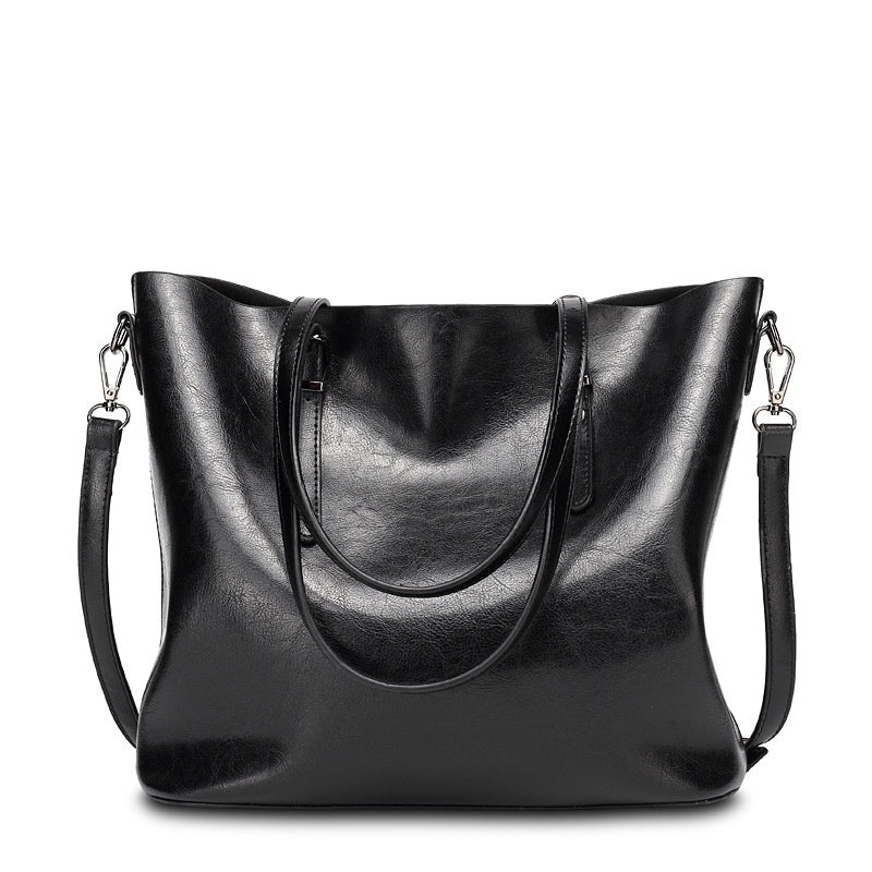Black leather handbag with shoulder straps on a white background