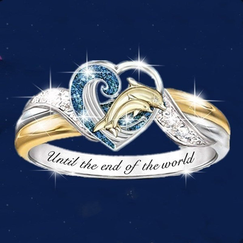 Ring with dolphins and heart design on a dark blue background