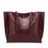 Maroon leather tote bag with handles on a white background