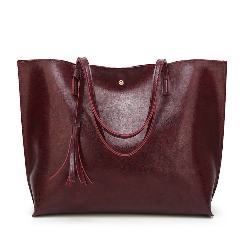 Maroon leather tote bag with handles on a white background