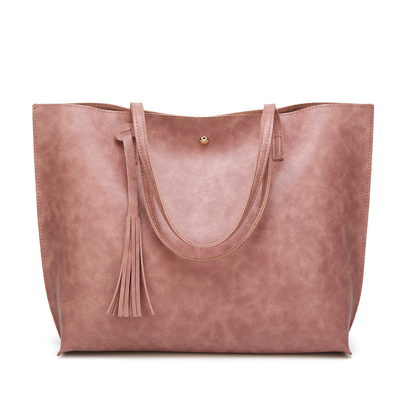 Pink tote bag with tassel on a white background
