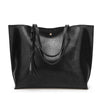 Black leather tote bag with tassels on a white background