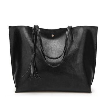 Black leather tote bag with tassels on a white background